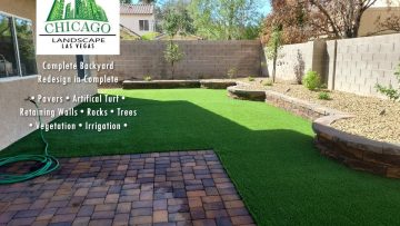 This complete backyard transformation by Chicago Landscape of Las Vegas showcases a seamless integration of functional hardscaping and water-smart greenery. The design features a large interlocking paver patio and a matching side walkway that transitions into a lush, synthetic turf lawn and elevated stone planter beds. The final result is a multi-textured outdoor oasis that combines professional masonry with low-maintenance desert landscaping and modern irrigation.