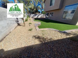 This complete backyard transformation by Chicago Landscape of Las Vegas showcases a seamless integration of functional hardscaping and water-smart greenery. The design features a large interlocking paver patio and a matching side walkway that transitions into a lush, synthetic turf lawn and elevated stone planter beds. The final result is a multi-textured outdoor oasis that combines professional masonry with low-maintenance desert landscaping and modern irrigation.