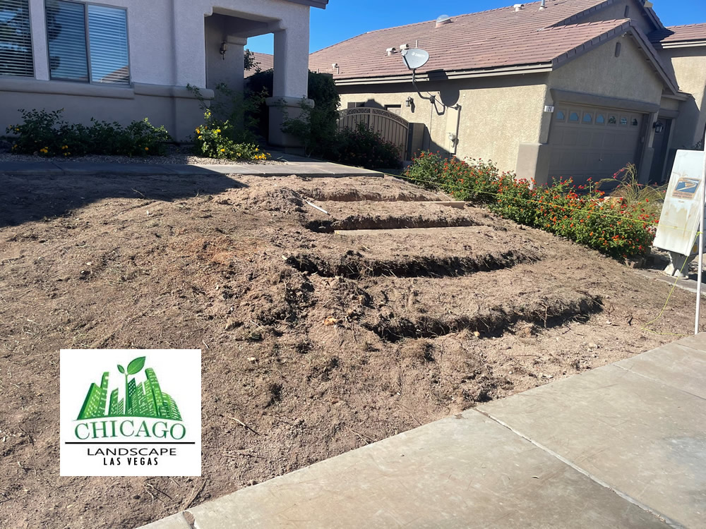 Dirt grading and site preparation for paver walkway installation during a Henderson landscape conversion.