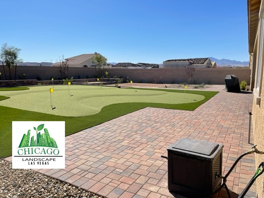 Completed Las Vegas backyard landscape redesign with custom putting green, artificial turf, paver patio, raised planting beds, decorative rock, and drought-tolerant landscaping.