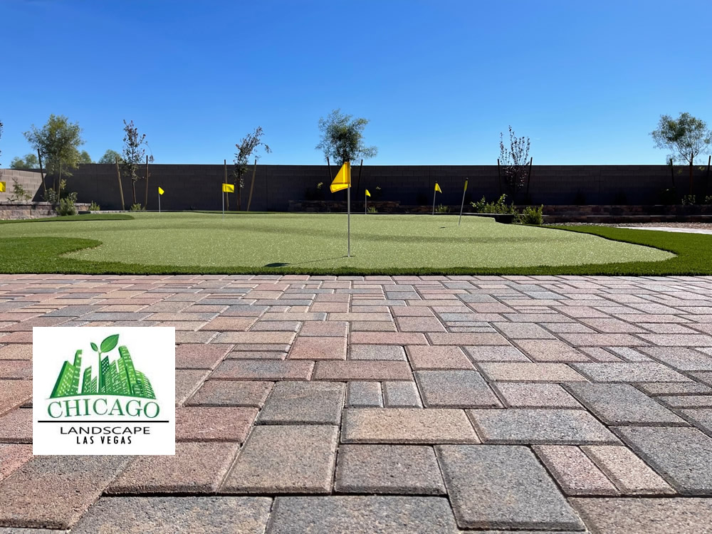 Completed Las Vegas backyard landscape redesign with custom putting green, artificial turf, paver patio, raised planting beds, decorative rock, and drought-tolerant landscaping.
