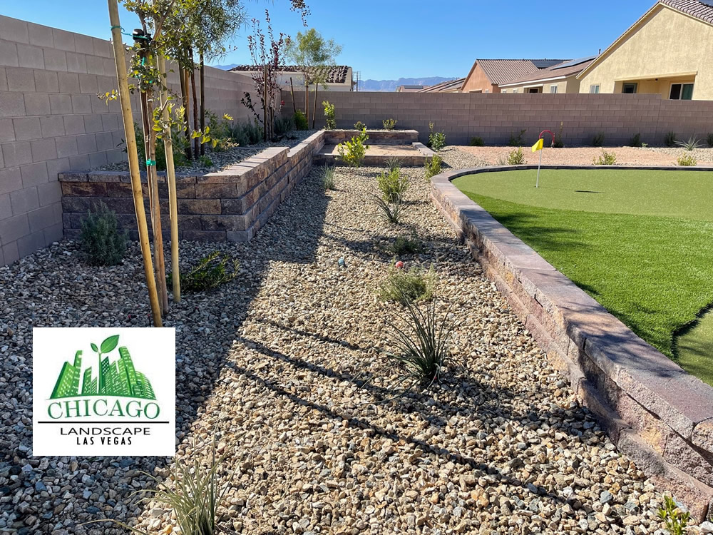 Completed Las Vegas backyard landscape redesign with custom putting green, artificial turf, paver patio, raised planting beds, decorative rock, and drought-tolerant landscaping.