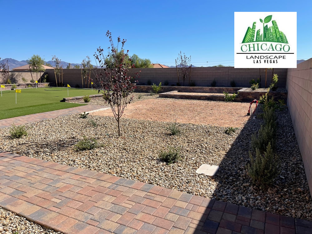 Completed Las Vegas backyard landscape redesign with custom putting green, artificial turf, paver patio, raised planting beds, decorative rock, and drought-tolerant landscaping.