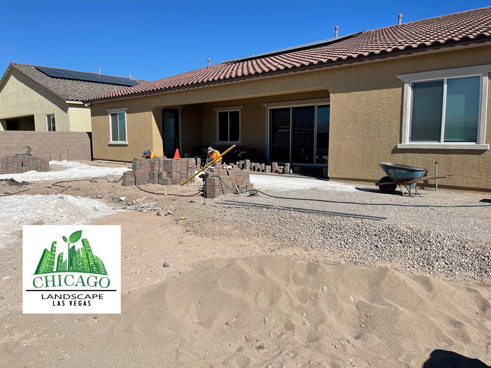 Backyard landscape renovation in progress in Las Vegas with demolition, paver installation, raised beds, irrigation work, and artificial turf preparation.