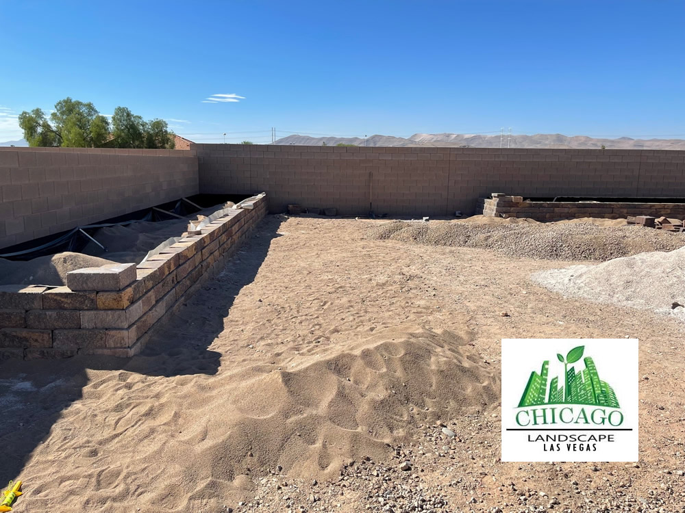 Backyard landscape renovation in progress in Las Vegas with demolition, paver installation, raised beds, irrigation work, and artificial turf preparation.