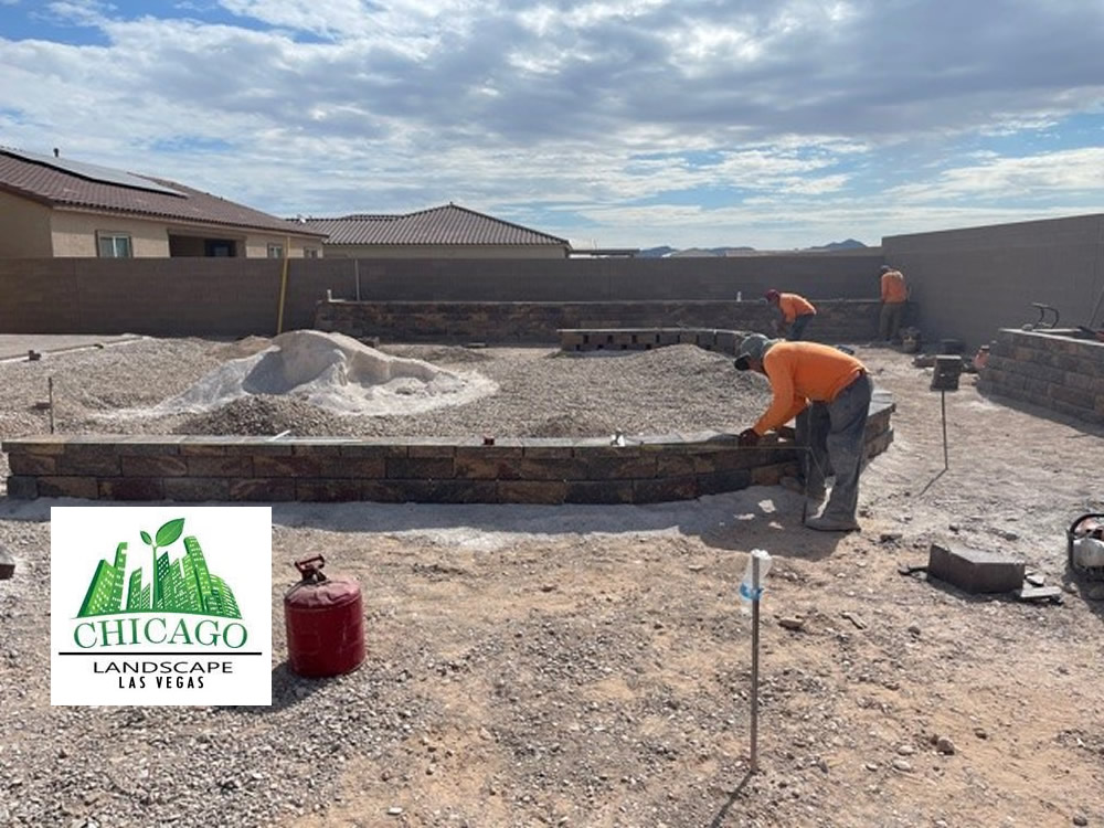 Backyard landscape renovation in progress in Las Vegas with demolition, paver installation, raised beds, irrigation work, and artificial turf preparation.