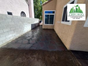 Photo shows slate walkway on side of house in backyard