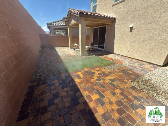 Completed Las Vegas backyard desert conversion with a multicolored paver patio, small lawn, and landscape rock.