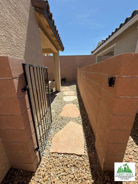Slate stepping stones set in landscape rock lead through the side gate toward the backyard patio.
