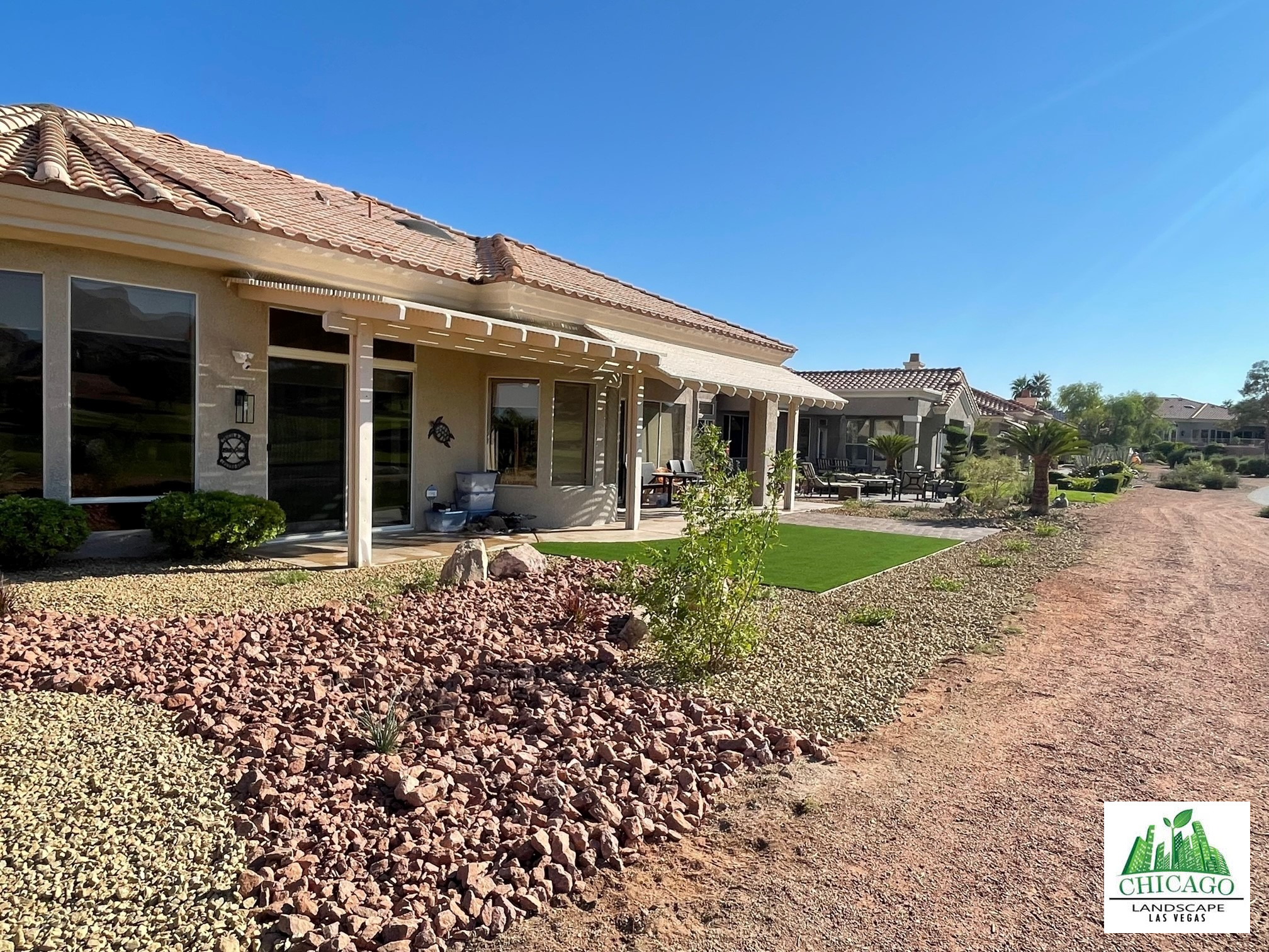 Backyard rock beds, synthetic turf, and low planting at a Sun City Summerlin home.