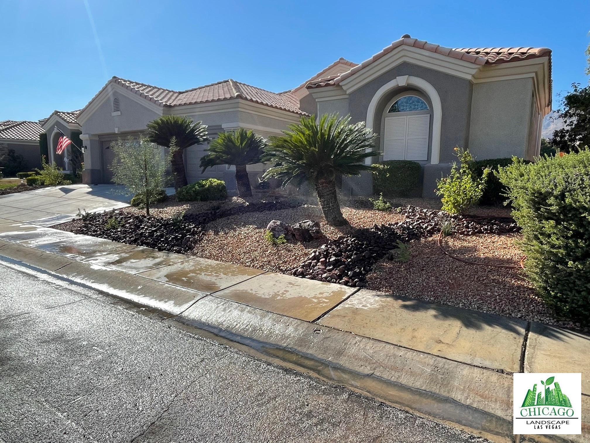 Street view of the completed front yard with decorative stone and planting.